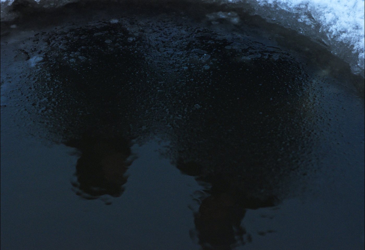 Dark water beneath a shelf of ice.